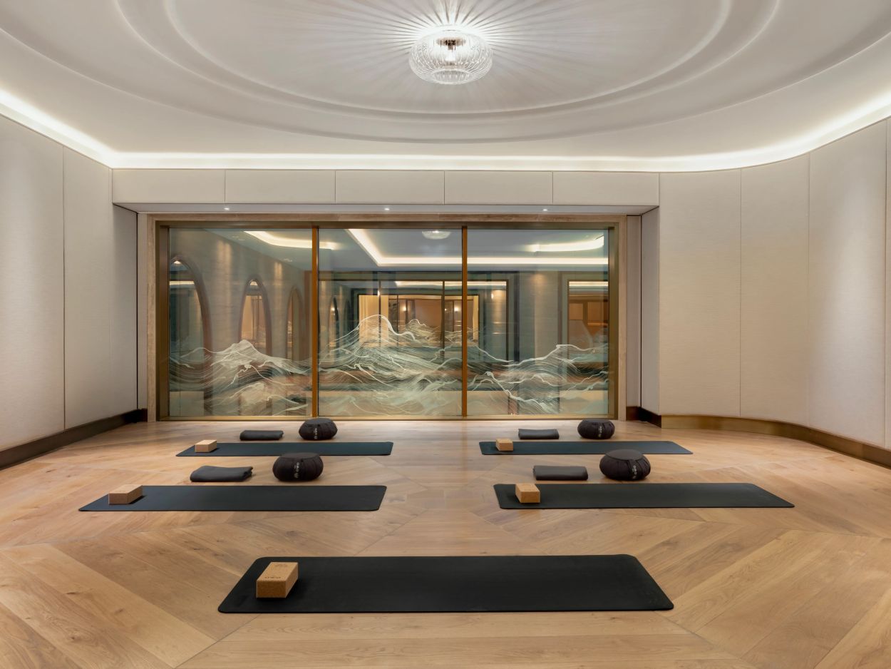 Luxurious yoga room with decorated glass screen.