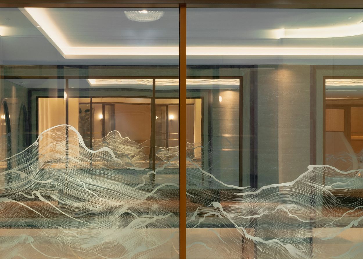 Ocean wave motif etched on glass lit from above at Guerlain Spa.