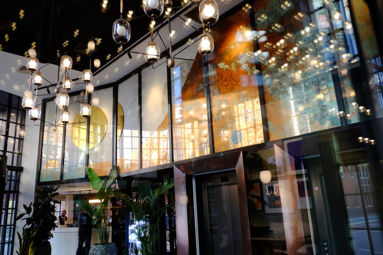 Wide view of reflective verre églomisé installation at lobby of Mondrian Shoreditch, London.