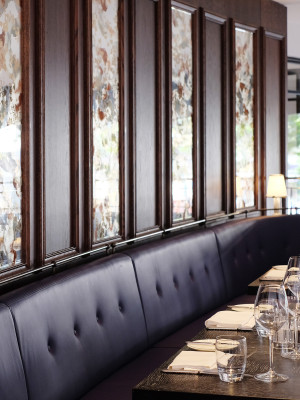 A series of verre églomisé glass panels above banquettes.