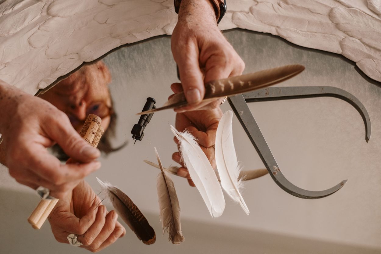 Tobias' hands with feathers.